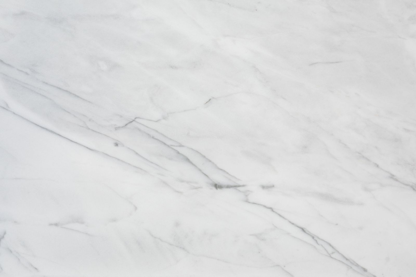 Carrara marble surface. Calcite marble, soft grey veining, Mohs 3.