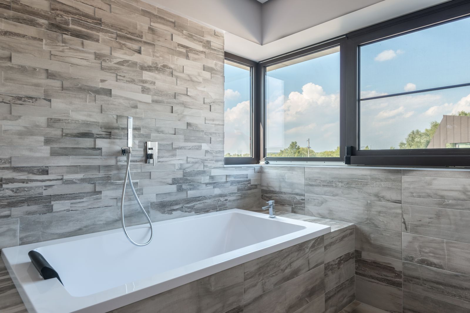 A finished Meridian bathroom in soft daylight, tile joints running unbroken to the corner.